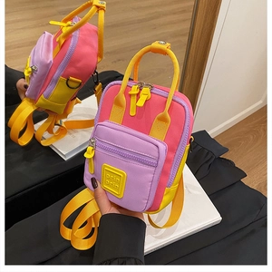 Detailed view of pink and purple mini backpack with three-color stitching and front pocket