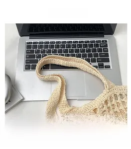 Détail des poignées souples et de la texture au crochet de ce sac cabas d'été beige