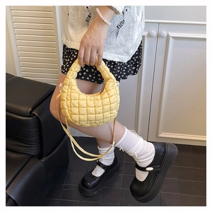 Detail of yellow quilted cloud bag with textured bubble fabric and thick handles