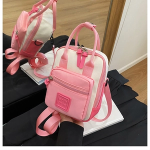 Detail of pink and cream crossbody bag with orin orin logo and adjustable straps