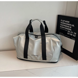 Detailed view of spacious silver gym bag with sturdy black handles and top double zipper