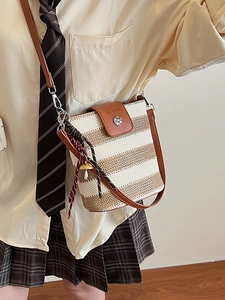 Sac seau tissé rayé avec rabat en cuir et breloque champignon sur un mannequin femme