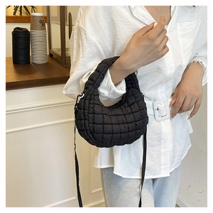 Lifestyle shot of black quilted cloud bag showing crossbody fit and size in a cafe
