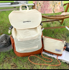Detail of multi-color casual canvas backpack set on grass with matching small crossbody bag