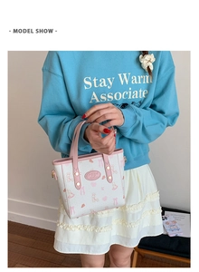 Detail of cream mini tote bag featuring cute pink rabbit prints and logo patch