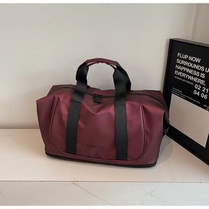 Detail of burgundy waterproof travel bag showing lower shoe compartment and logo