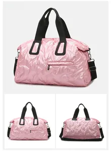 Pink glossy quilted travel bag with black handles and detachable shoulder strap detail