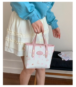 Detail of white printed handbag with pink rabbit motif and sturdy double handles