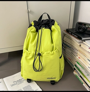 Detail of neon green nylon backpack with drawstring closure and front storage pocket