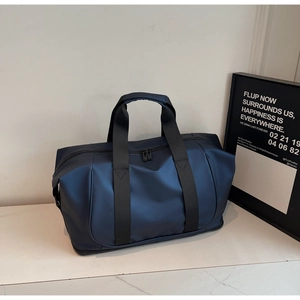 Detail of navy blue waterproof travel bag showing the matte texture and nylon handle