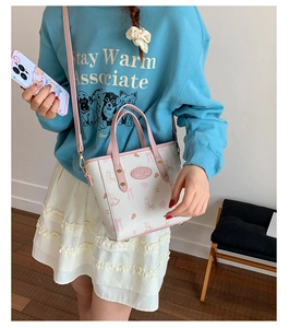 Detail of sweet cartoon bucket bag with pink leather trim and floral bunny prints