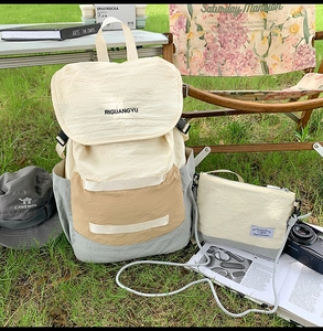 Outdoor canvas backpack set with matching crossbody bag and sun hat on grass