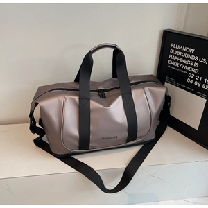 Detail of expandable champagne travel bag featuring durable handles and metal zippers