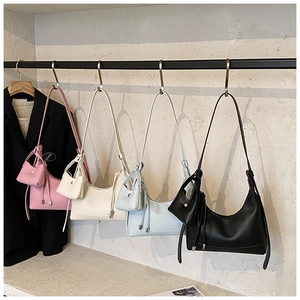Detail view of four textured leather hobo bags in pink, white, blue, and black colors