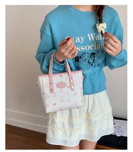 Detail of pink and white printed bucket bag with cartoon rabbit and bow motifs