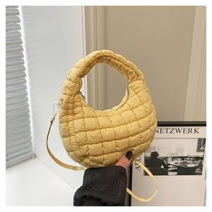 Close-up of bright yellow quilted half-moon bag featuring a soft puffy fabric texture