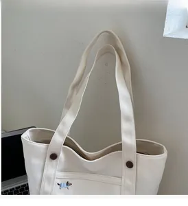 Détail du sac fourre-tout en toile crème avec broderie de chien et boutons marron déco
