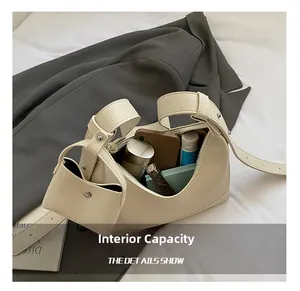 Detail showing the inner capacity of a minimalist baguette bag with phone and cosmetics