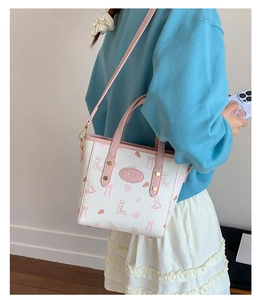 Detail showing white bucket bag with pink rabbit prints and adjustable shoulder strap