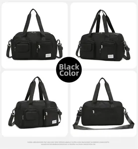 Detail view of black travel bag showing front pockets and detachable shoulder strap