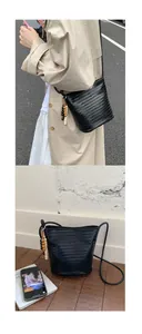 Detail of black woven bucket bag featuring decorative beads and versatile shoulder strap