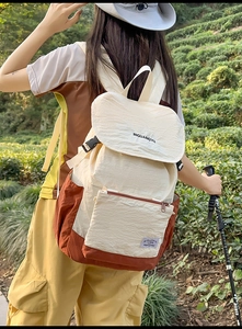 Outdoor lifestyle shot of a color-block canvas backpack with large capacity and straps