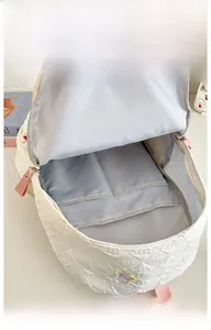 Detail shot of the large capacity white backpack showing internal pockets and star embroidery