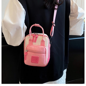Pink and beige crossbody bag with dual zippers and adjustable straps for travel