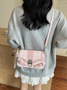 Borsa sottobraccio a quadretti rosa con catena di perle e fiocco indossata dalla modella