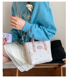 Detail of white mini bucket bag with pink rabbit print and adjustable shoulder strap