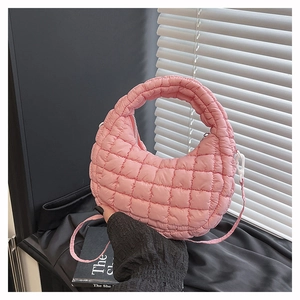 Detail of pink quilted hobo bag featuring nylon fabric texture and detachable strap