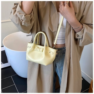 Borsa a secchiello giallo chiaro con fiocco e tracolla in pelle in un contesto lifestyle