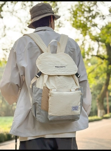 Detail of a lightweight cream and gray hiking backpack with buckle closure and texture