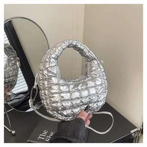 Detail of silver metallic puffer bag with quilted pattern and detachable crossbody strap
