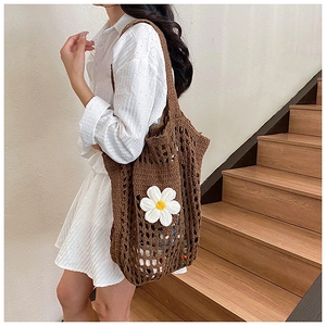 Détail du sac cabas en crochet marron tissé main avec une grande fleur de marguerite