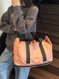Peach pink expandable travel bag with a separate bottom compartment and black straps