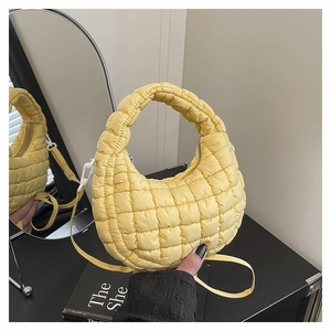 Detail of yellow quilted hobo bag featuring bubble texture and detachable shoulder strap