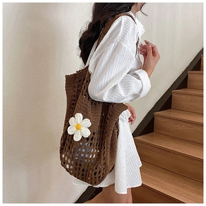 Vue latérale du sac fourre-tout au crochet marron avec marguerites porté par un mannequin