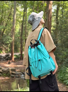 Outdoor waterproof nylon drawstring backpack shown in a lush forest and stream setting