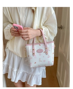 Detail of small pink tote bag with cartoon rabbit print and side strap D-ring connector