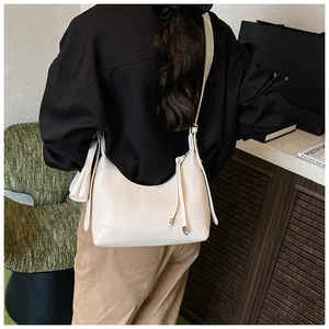 Detail of minimalist off-white crescent shoulder bag with lychee texture and small pouch