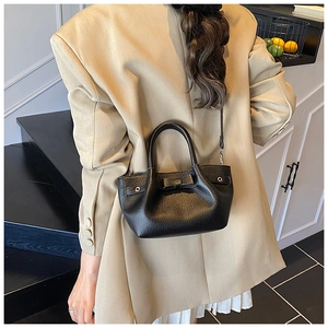 Vista posteriore di una borsa a secchiello in pelle nera con fiocco su una modella