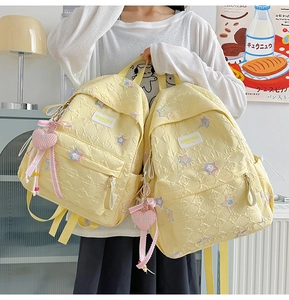 Close-up of quilted star backpack featuring heart charm and soft cream fabric texture