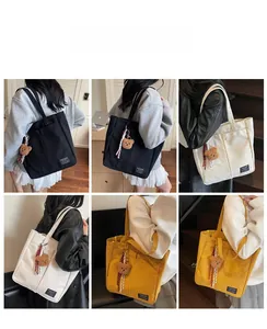 Detail of large canvas tote bags in black, beige and yellow with a cute teddy bear charm
