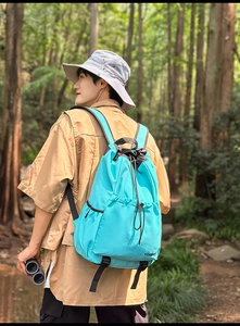 Close-up of lightweight blue nylon hiking backpack with drawstring closure and side pockets