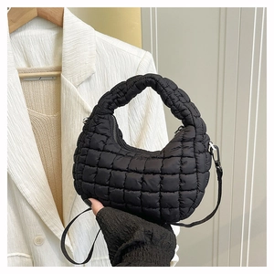 Detail of black quilted cloud bag showing nylon texture and silver metal strap hook