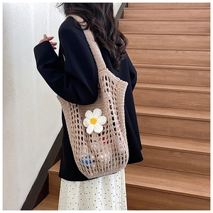 Détail du sac fourre-tout en paille tissé à la main avec une marguerite blanche en 3D