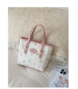 Detailed close-up of a white cartoon rabbit print bucket bag with pink leather handles