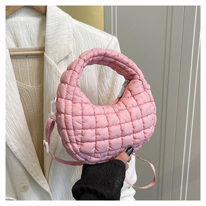 Detail of pink quilted cloud handbag with soft puffy texture and crossbody strap