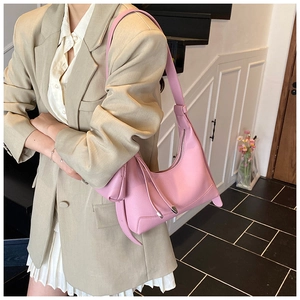 Detail of pink faux leather hobo bag with matching coin purse on a beige blazer